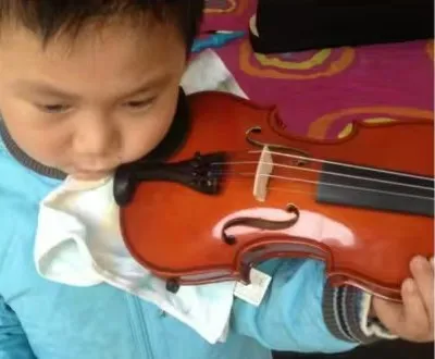 Close-up of young Zimo holding a violin