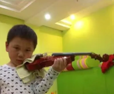Young Zimo practising the violin in a classroom