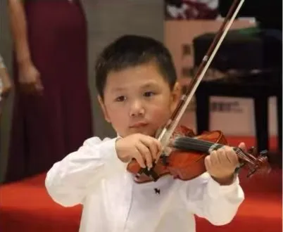 Zimo as a young child playing the violin