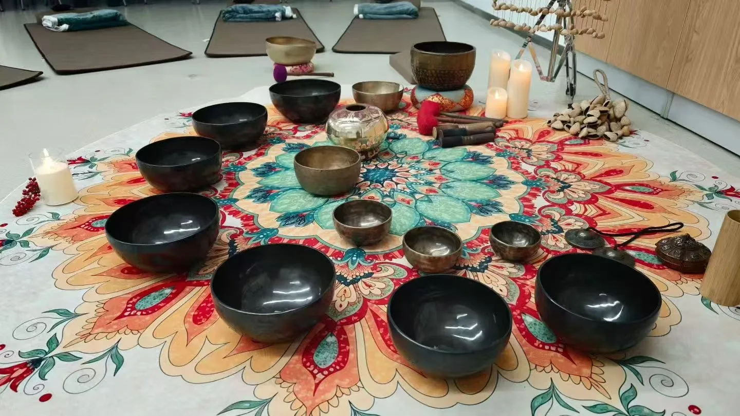 Singing bowls arranged on a rug for a club session