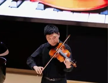 Zimo performing a viola solo in concert dress